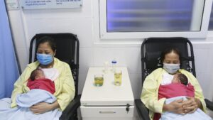 Hai con song sinh của bà Lan trong vòng tay mẹ và bác /// ẢNH LT